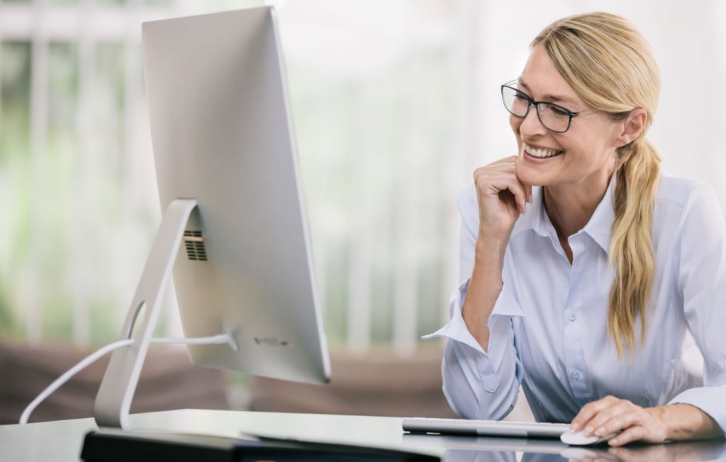 Femme souriante devant un ordinateur