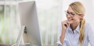 Femme souriante devant un ordinateur